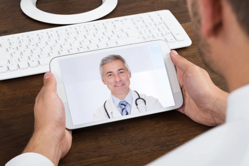 A person holding a mobile device with a picture of a doctor on the scree