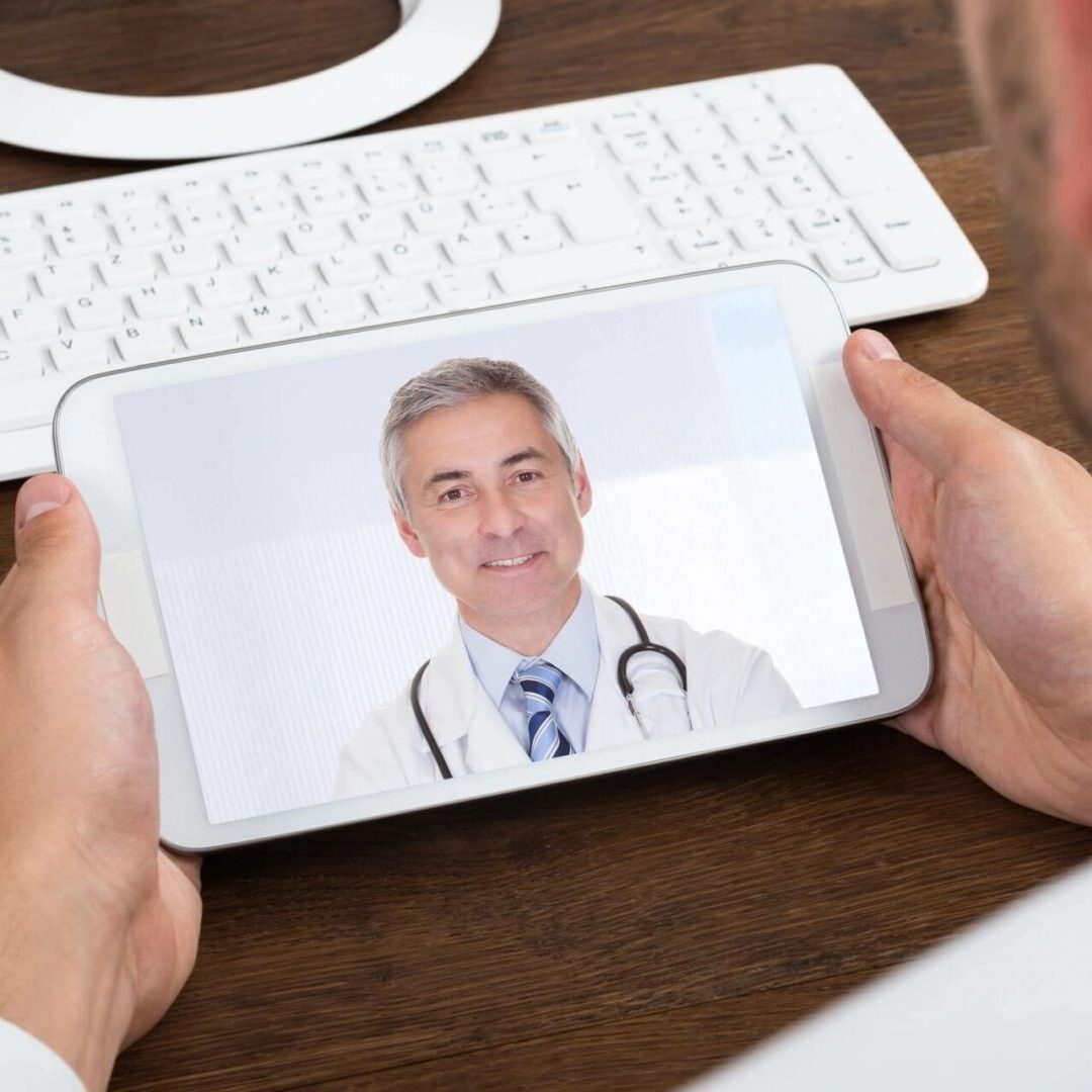 A person holding a mobile device with a picture of a doctor on the scree